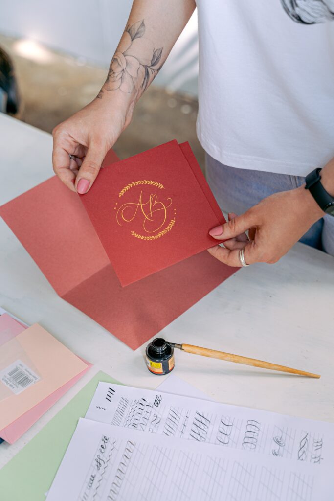 Frau verschönert Einladungskarten mit Kalligraphie