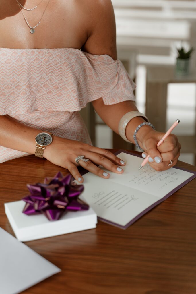 Frau fügt Hochzeitseinladungen eine persönliche Notiz hinzu